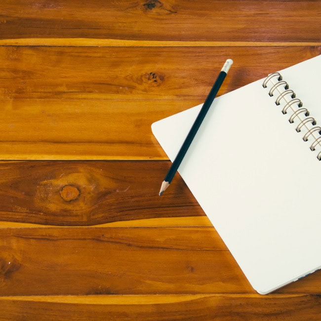 libreta y lapiz sobre madera