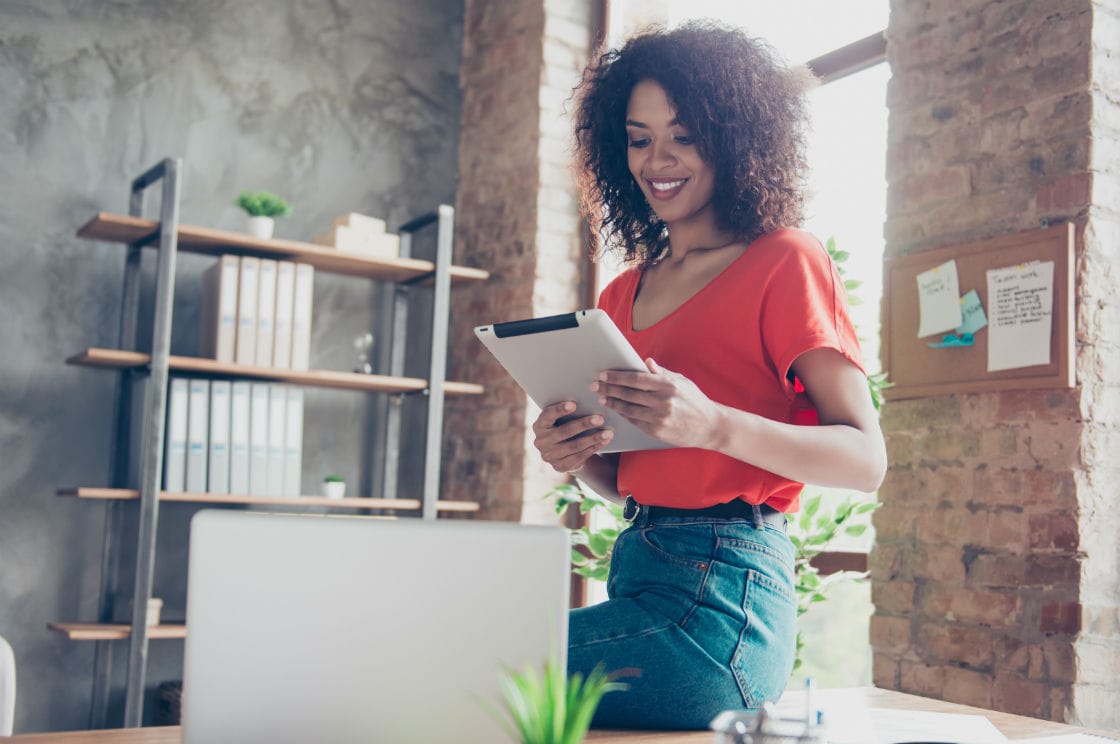 imagen de una joven frente a una tablet y un ordenado