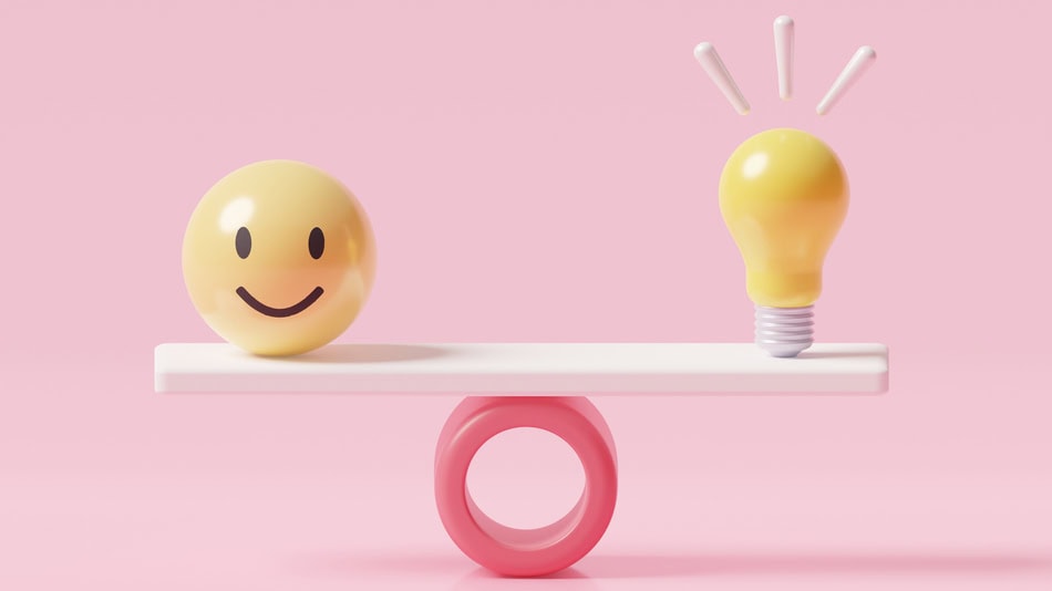 Una bola con cara feliz y una bombilla brillante en una báscula de ponderación equilibradas