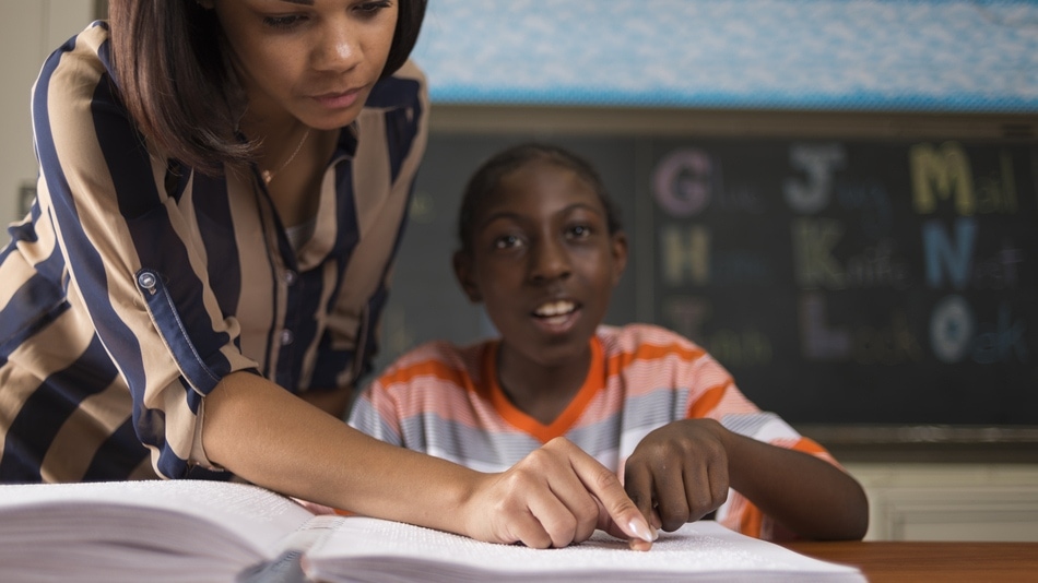 Ni&ntilde;o aprendiendo Braille con la profesora en clase